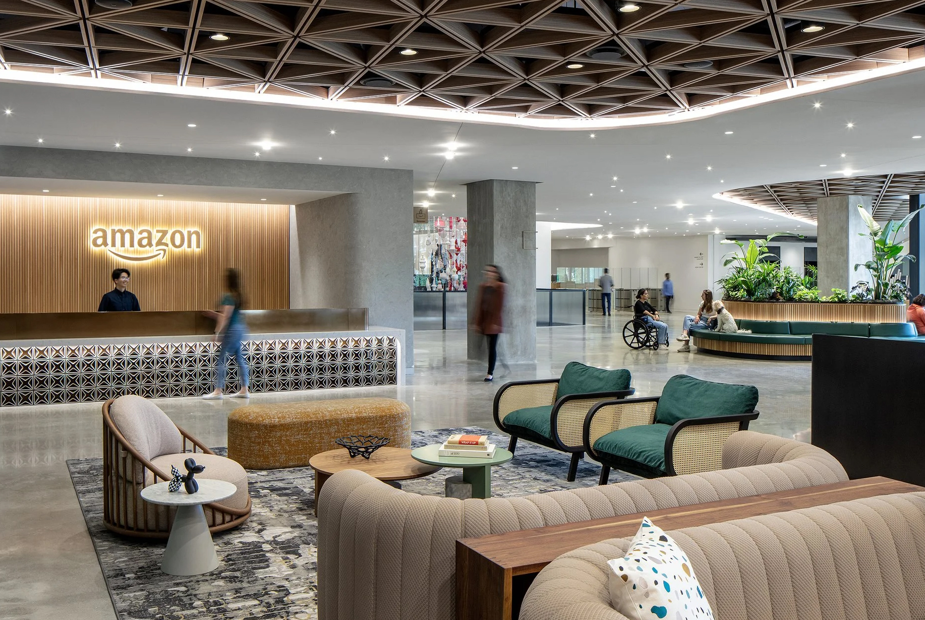 The lobby of an Amazon building, with a person standing at reception, and a comfortable seating area.