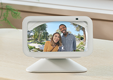 A device with a screen shows two people smiling into a camera.