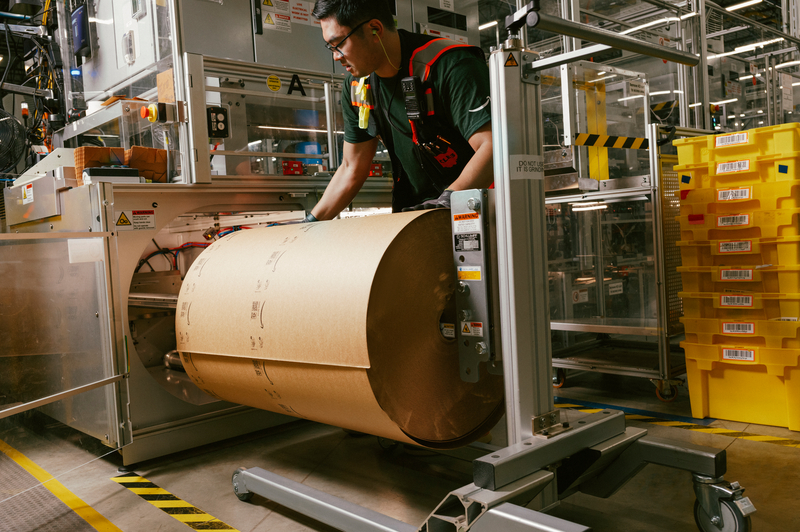 A person loads paper onto a machine.