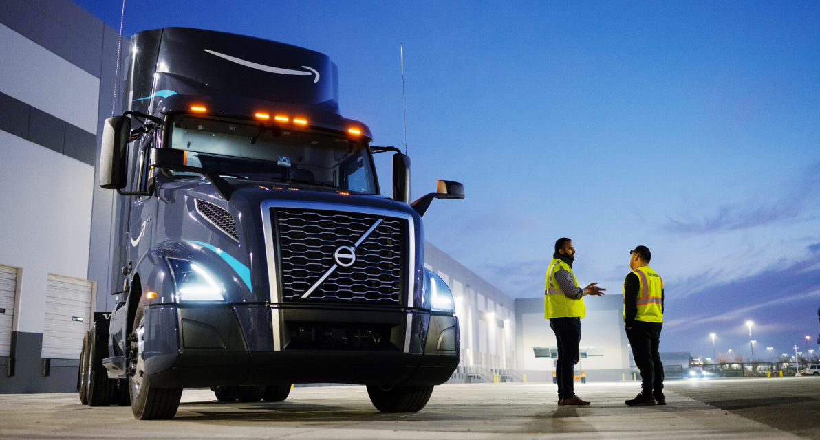 Two people stand next to a truck.