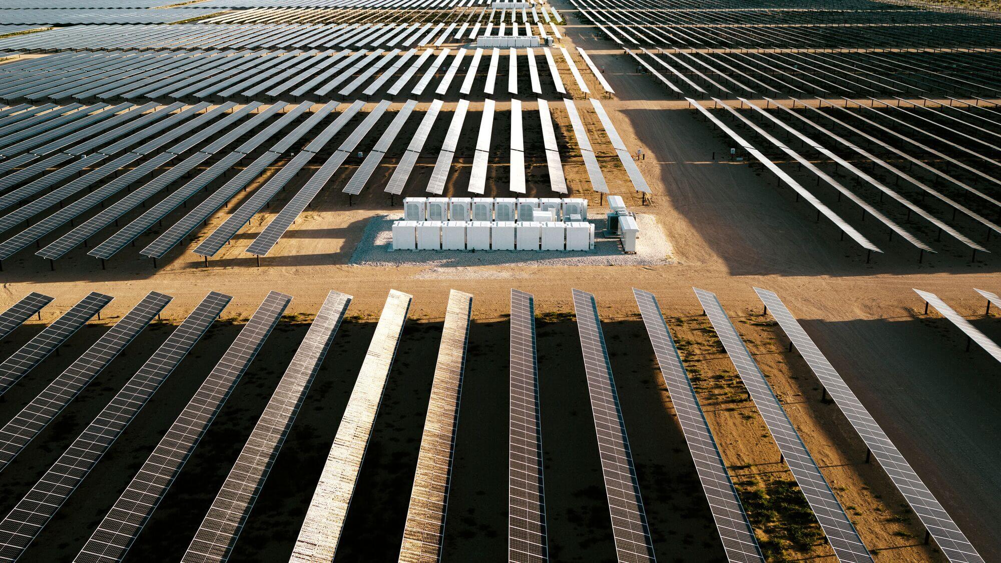 Rows of solar panels in a dry field.