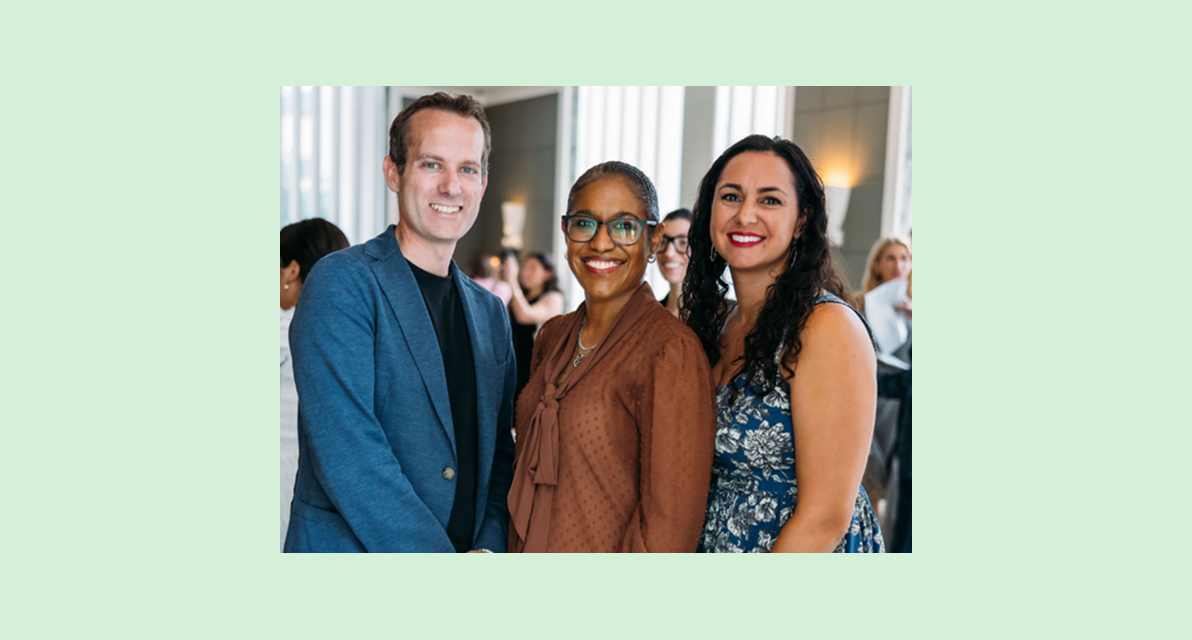 A group of people smiling for a photo at an event. 