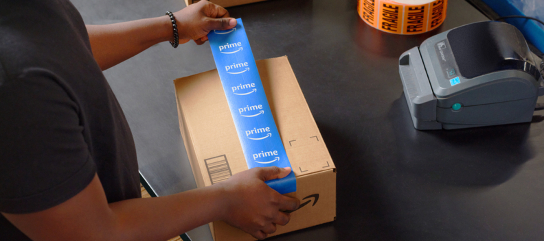 A person places blue tape on top of a package. 